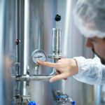 Technician performing hydrostatic pressure test in a certified materials lab